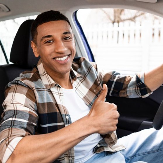 Man smiles in car