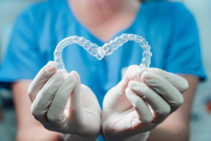 Dentist holding SureSmile trays in the shape of a heart