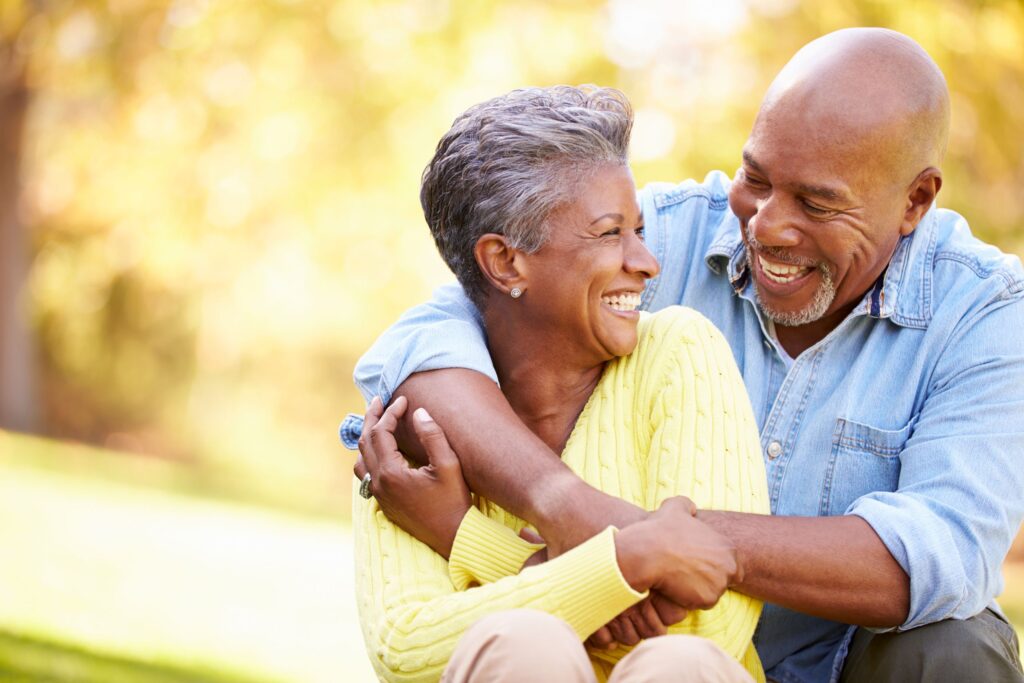 Man in blue shirt hugging woman in yellow sweater outside